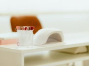 a white table with a glass of toothbrushes on top of it