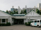 A white building with a van in front.
